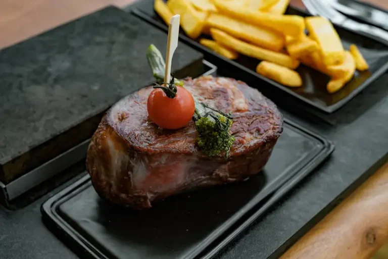 Dry Aged Rib-Eye Steak auf heißer Steinplatte mit Pommes und Soßen bei Pasta König Rheinfelden